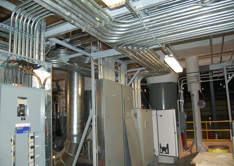 Industrial facility floor with electrical infrastructure and technicians